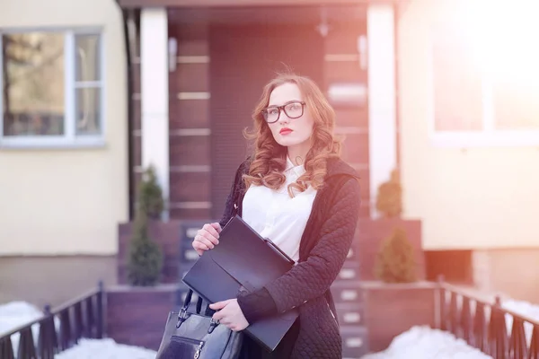 Femme d'affaires fille au printemps sur une promenade dans un manteau — Photo