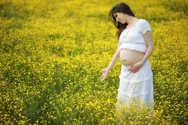 孕妇穿着花地里的连衣裙 — 图库照片