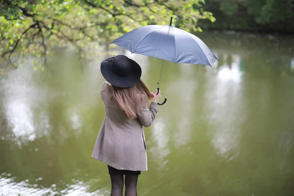 Giovane ragazza in cappotto in un parco primaverile — Foto Stock