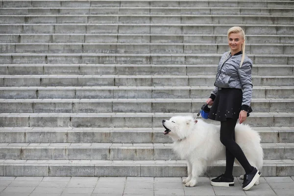 Härlig flicka på promenad med en vacker hund — Stockfoto