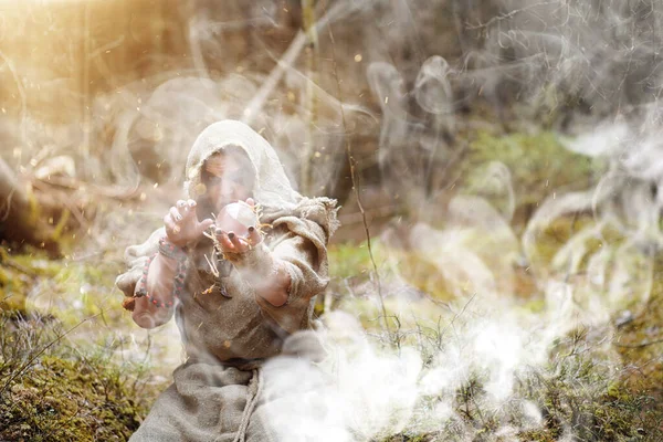 En man i en Kaftan tillbringar en ritual i en mörk skog — Stockfoto