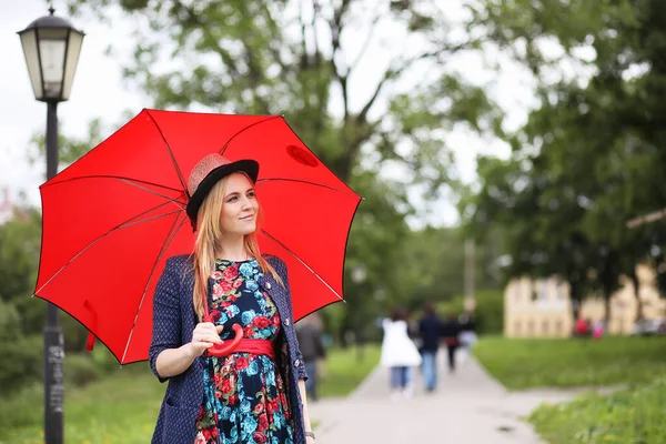 Mädchen auf der Straße mit einem Regenschirm — Stockfoto