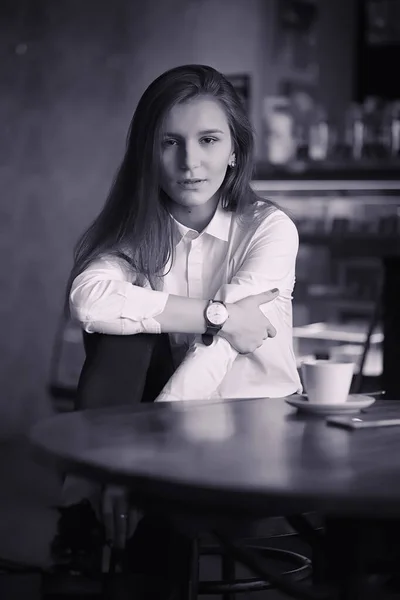 Uma rapariga num café está a beber café. Uma mulher está tomando café da manhã — Fotografia de Stock