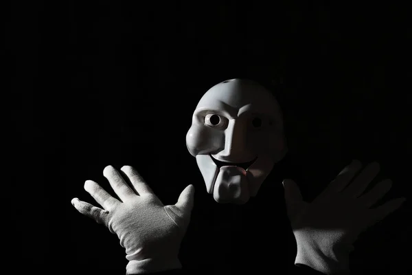Fehér ijesztő maszk egy fekete háttér fehér kéz. — Stock Fotó