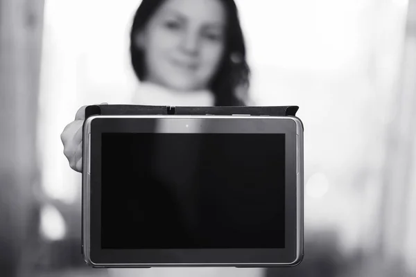 The girl is holding a tablet. The girl has a computer with a scr — Stock Photo, Image