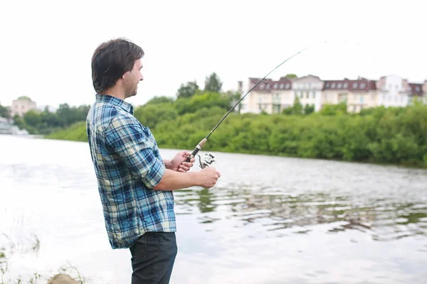 Un hombre con barba está pescando en el río — Foto de Stock
