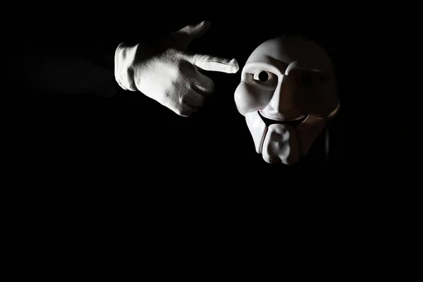 Біла страшна маска на чорному тлі з білою рукою . — стокове фото