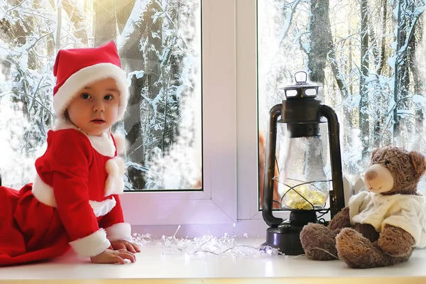 Un niño en el nuevo año mira por la ventana. Los niños son camareros — Foto de Stock