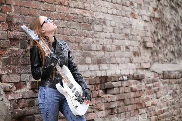 Rockový hudebník holka v kožené bundě s kytarou — Stock fotografie