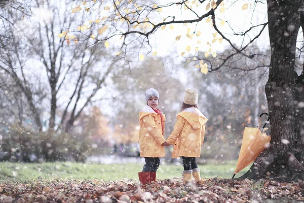 I bambini camminano nel parco prima neve — Foto Stock