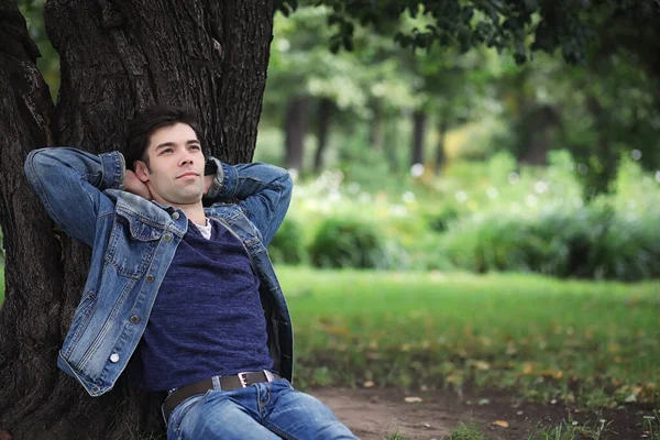 A young man walks in the park at lunch time. A man is on a walk Stock Photo