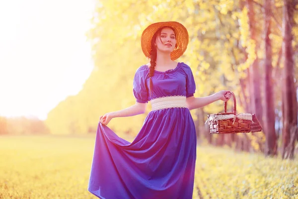 Young beautiful girl in dresses on nature. A girl in a hat walks Royalty Free Stock Photos