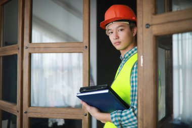 Kask ve inşaat koruyucu yelek Asyalı adam