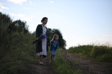 Anne ve kızı yolda yürüyor.