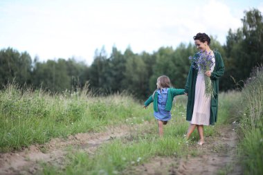 Anne ve kızı yolda yürüyor.