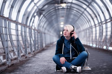 Genç öğrenci metro büyük kulaklıklar müzik dinlemek