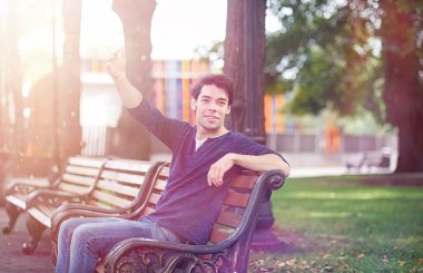 Genç bir adam öğle yemeği zamanında parkta yürür. Bir adam yürüyüşe çıktı. 