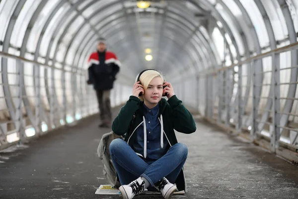年轻的姑娘在听音乐在地铁里大耳机 — 图库照片