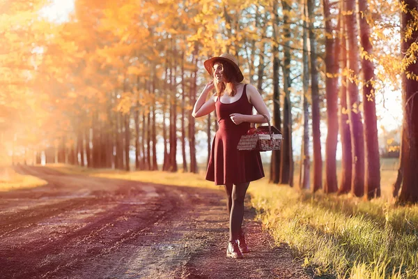 Ein Mädchen mit Hut bei einem Spaziergang im Park. ein Mädchen mit einem Korblauf — Stockfoto