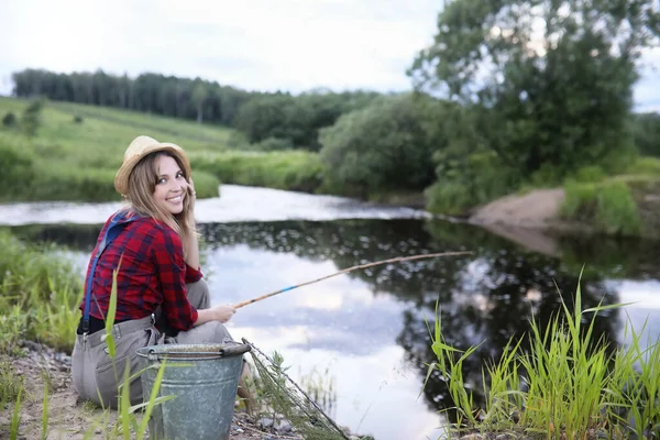 Ragazza vicino al fiume con una canna da pesca — Foto Stock