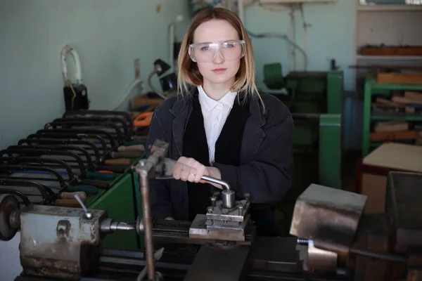 Young woman engineer working at machine tool — Stock Photo, Image