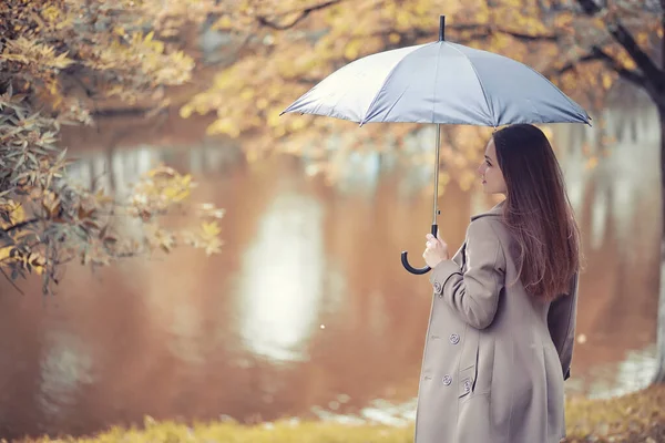 Herbstliches Regenwetter und ein junger Mann mit Regenschirm — Stockfoto