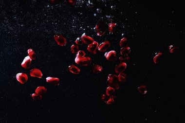 Olgun tatlı nar tohumlarına su damlaları düşer. Metnin için kopyalama alanı olan taze nar arkaplanı. Vejetaryen ve vejetaryen kavramı.