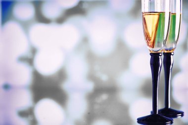 Köpüklü şaraplar için uzun bardaklı bir arka plan. Cam bardaklarda şampanya spreyi. Yansımalı kutlama içkisi.