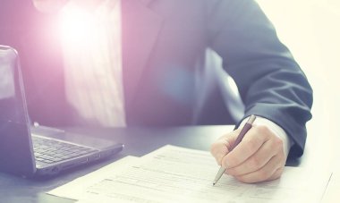 Müdür ofisteki bir dizüstü bilgisayarda çalışıyor. İşadamı çevrimiçi işlem yapıyor. Değiş tokuş internet üzerinden yapılıyor..