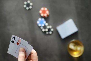 Para için kumar kartı oyunları. Texas Poker Pokeri. Eldeki kartlar, oyun fişleri, bardaktaki bir deste alkol..