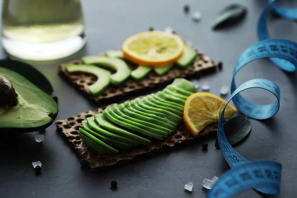 Avokado yemek tarifleri. Tahta kesme tahtasında servis edilen olgun yeşil avokado..