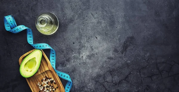 Avokado yemek tarifleri. Tahta kesme tahtasında servis edilen olgun yeşil avokado..