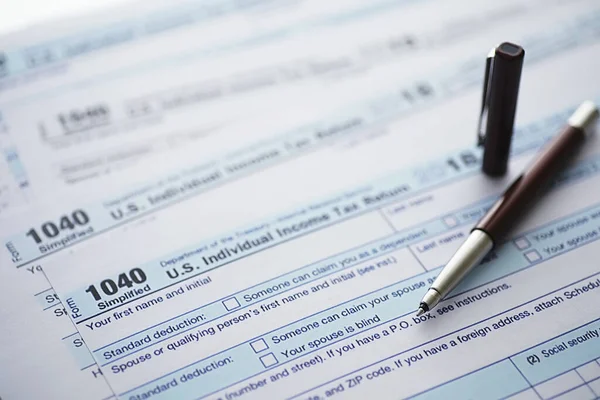 Annual tax reporting. Tax form on the table. Financial statements signature.