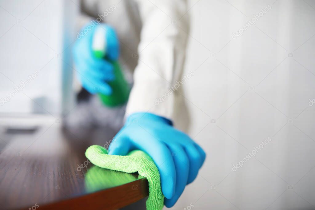 House cleaning concept. Wipe dust off surfaces. Disinfectant treatment door handles TV electrical. Sanitary treatment at home in quarantine.