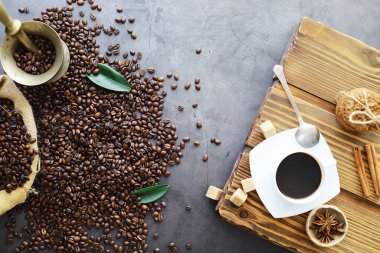 Bir poşet kahve. Kahve çekirdekleri masada kavrulmuş. Pişirmek için yapraklı kahve çekirdekleri.