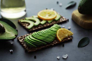 Avokado yemek tarifleri. Tahta kesme tahtasında servis edilen olgun yeşil avokado..