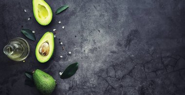 Avokado yemek tarifleri. Tahta kesme tahtasında servis edilen olgun yeşil avokado..