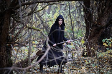 Bir kadın bir ritüel üzerinde yoğun bir orman içinde bir cadı elbiseli