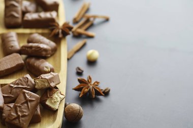 Arkaplanda siyah arka planda çikolatalar. Doldurulmuş çikolata. Atıştırmalık tatlı ve çay.