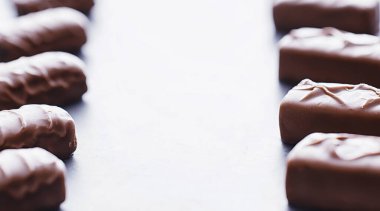 Arkaplanda siyah arka planda çikolatalar. Doldurulmuş çikolata. Atıştırmalık tatlı ve çay.