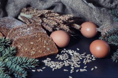 Siyah bir masada buğday ve glüten ile taze somun ekmek. Fırın ve market konsepti. Taze, sağlıklı çavdar ve beyaz somun ekmeği, çuval bezi üzerine serpiştirilmiş un. Tahıllı taze ev yapımı ekmek..