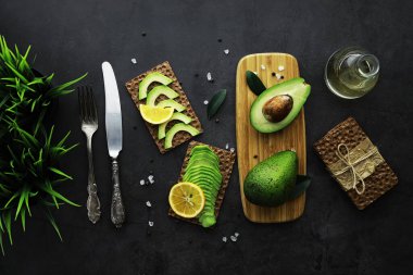 Avokado yemek tarifleri. Tahta kesme tahtasında servis edilen olgun yeşil avokado..