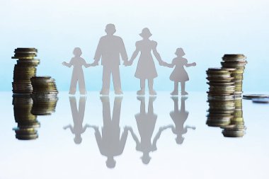 Dört kişilik siluet ve yığınla para. Aile kavramı. Aile bütçesi. Tasarruf yatırımı.