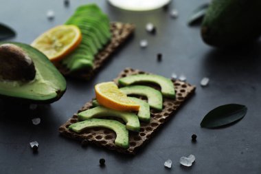 Avokado yemek tarifleri. Tahta kesme tahtasında servis edilen olgun yeşil avokado..