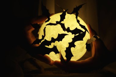 Ayın arka planında siyah yarasa siluetleri. Cadılar Bayramı konsepti Ürkütücü bir geçmiş. Cadılar Bayramı için korkunç soyut nesneler.