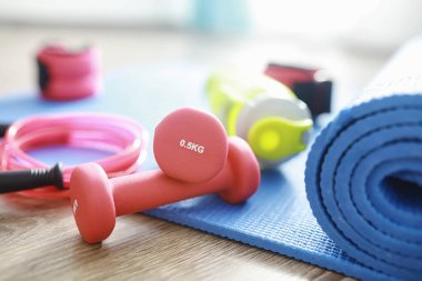 Spor ve sağlıklı yaşam tarzı. Spor aksesuarları. Yoga paspası ve halat atlama. Ev egzersizleri kavramına sahip spor geçmişi.