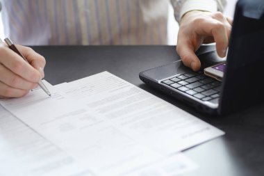Müdür ofisteki bir dizüstü bilgisayarda çalışıyor. İşadamı çevrimiçi işlem yapıyor. Değiş tokuş internet üzerinden yapılıyor..