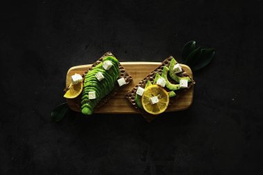 Avokado yemek tarifleri. Tahta kesme tahtasında servis edilen olgun yeşil avokado..