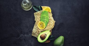 Avokado yemek tarifleri. Tahta kesme tahtasında servis edilen olgun yeşil avokado..