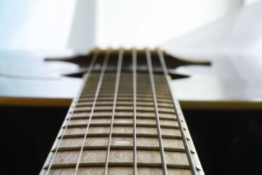 Sahnede telli bir enstrüman çalan sanatçı için akustik gitar. Capo 'lu siyah gitar. Müzik arkaplanı.